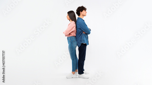 Obraz na plátně Unhappy Young Couple Crossing Hands Standing Back To Back, Studio