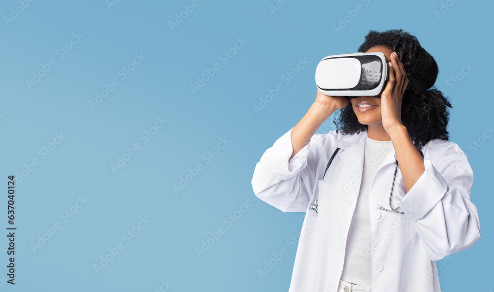 Glad inspired black millennial lady doctor in white coat and vr glasses looks at free space Glad inspired black millennial lady doctor in white coat and vr glasses looks at free space