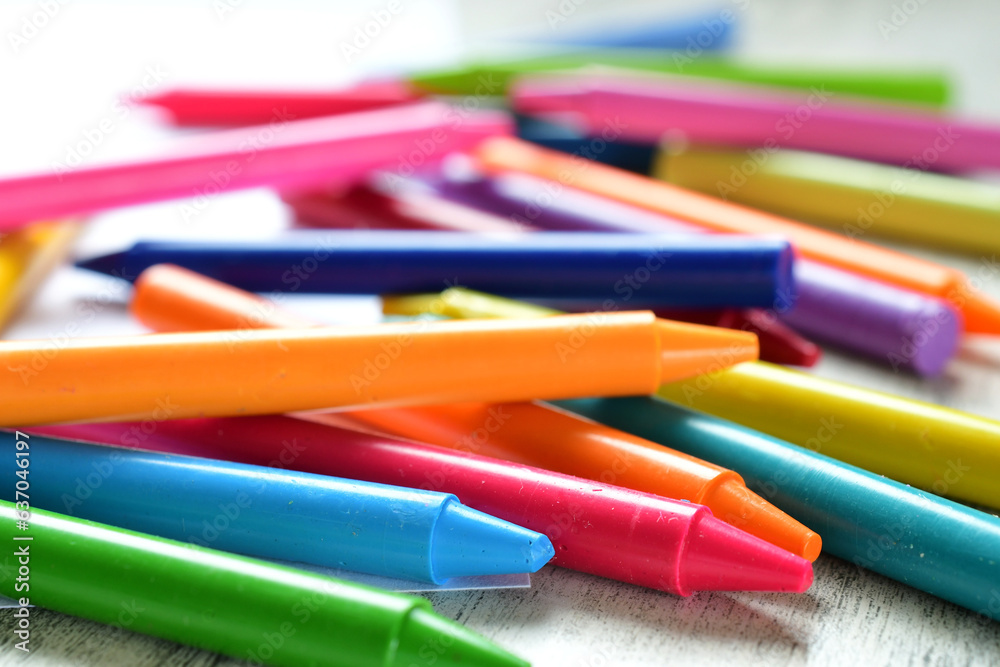 Bright colorful generic crayons on blank white paper - back to school background concept