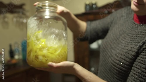 Homemade alcoholic drink limoncello in the home kitchen in the Italian village. Woman mixing lemon peel with alcohol in the jar 4K