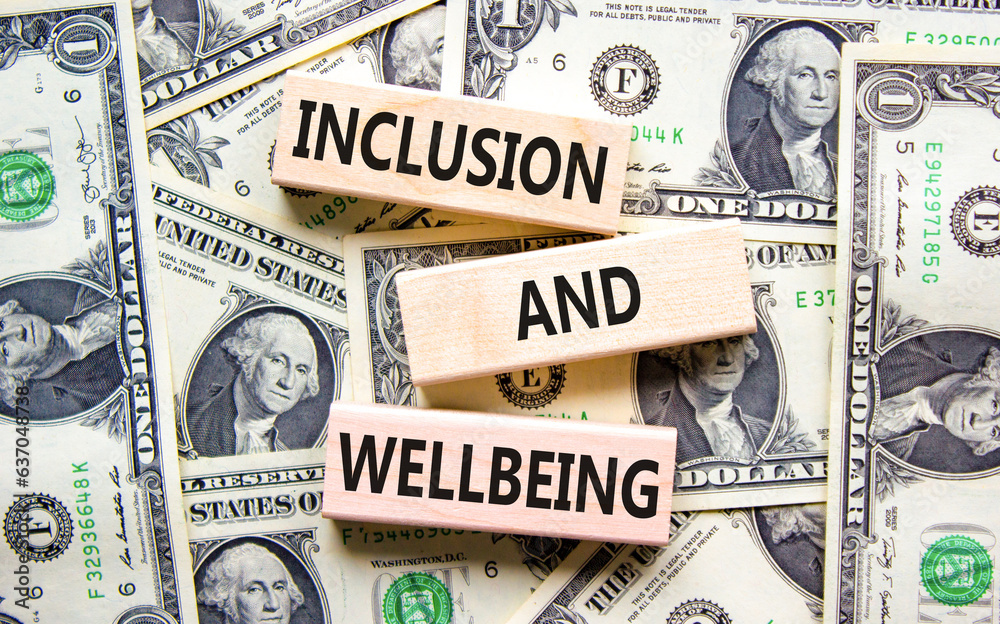 Inclusion and wellbeing symbol. Concept words Inclusion and wellbeing on wooden block. Dollar bills. Beautiful background from dollar bills. Motivational inclusion and wellbeing concept. Copy space.