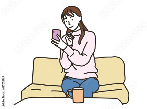 笑顔でスマホを見る私服姿の若い女性
