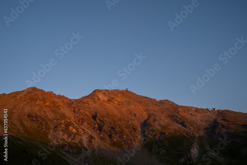 une montagne rouge au lever du soleil avec un ciel bleu intense