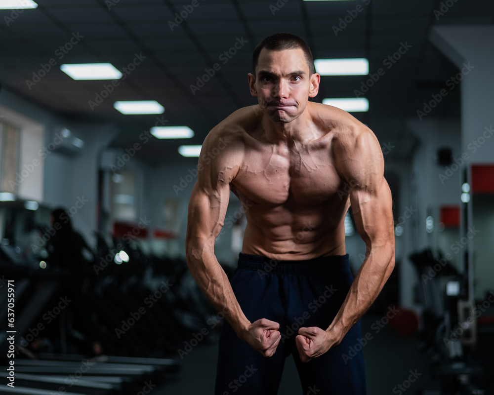 Shirtless man with sculpted body posing in the gym. Shirtless man with sculpted body posing in the gym.
