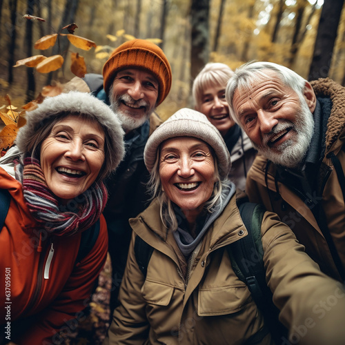 Selfie of group of active seniors, elderly men and women, on walk in autumn forest, concept of an active lifestyle at any age, playing sports