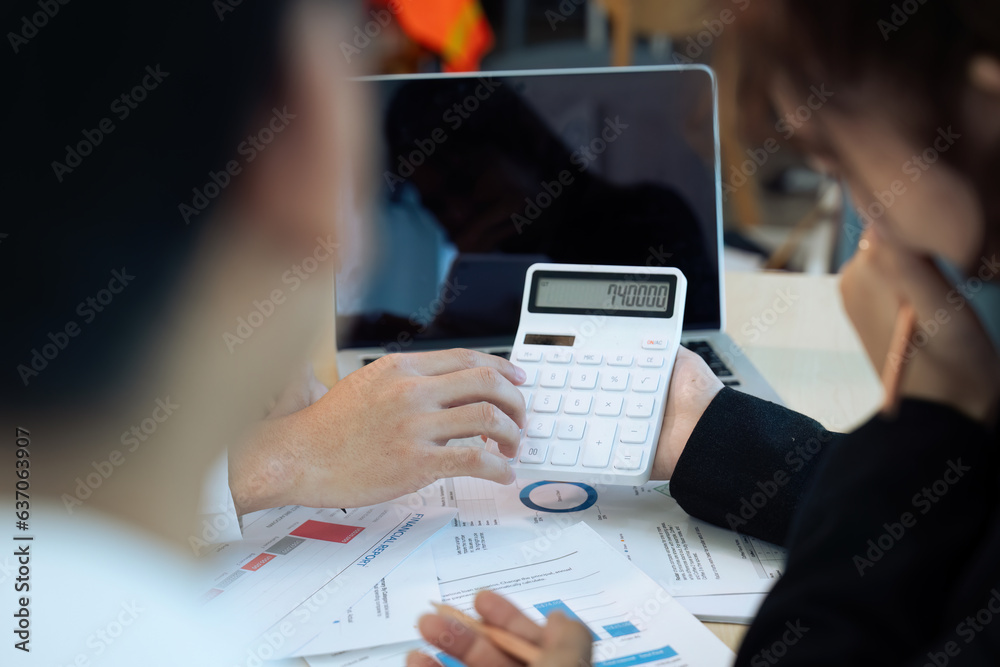 Obraz na plátně Businesswoman using a calculator to calculate numbers on a company's financial documents, analyzing historical financial data to plan how to grow the company