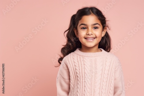 Portrait of a cute little girl smiling at camera isolated on a pink background
