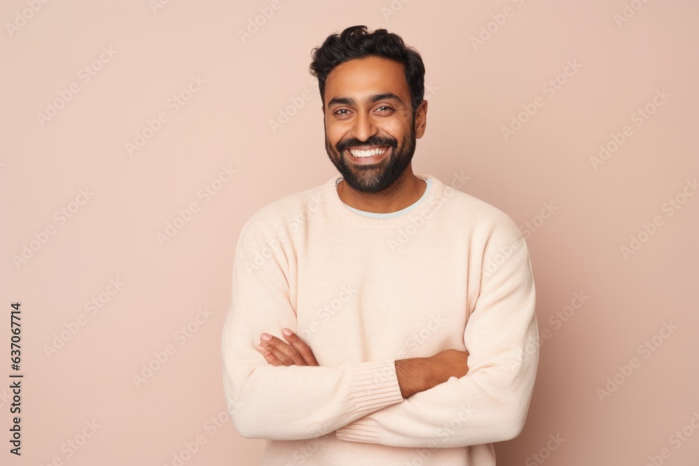 Portrait of a happy indian man standing with arms crossed and looking at camera Portrait of a happy indian man standing with arms crossed and looking at camera