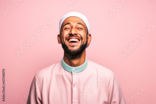 Portrait of a happy arabic man laughing. Isolated over pink background