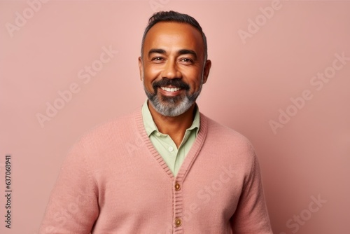 Portrait of an Indian man in a pink sweater on a pink background © Leon Waltz