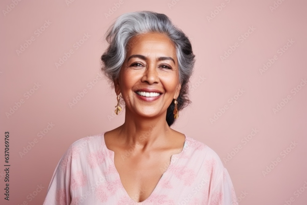 Portrait of a happy senior woman looking at camera over pink background Portrait of a happy senior woman looking at camera over pink background