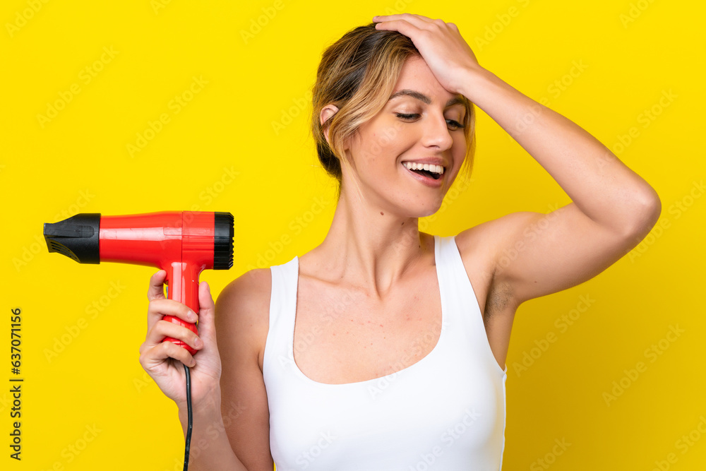 Young Uruguayan woman holding a hairdryer isolate don yellow background has realized something and intending the solution Young Uruguayan woman holding a hairdryer isolate don yellow background has realized something and intending the solution