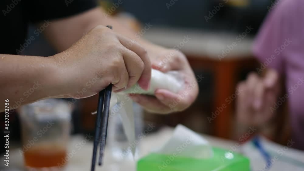 Tourists prepare and eat spring roll with rice paper wrapper or banh trang at night streetfood market. Traditional Vietnamese nem dish, asian cuisine. Close up Tourists prepare and eat spring roll with rice paper wrapper or banh trang at night streetfood market. Traditional Vietnamese nem dish, asian cuisine. Close up