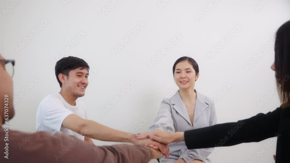 Group of diverse asian people spending time to talking and sharing about success and congratulate them stacking hands together at psychological therapy group meeting. 4k Resolution. Group of diverse asian people spending time to talking and sharing about success and congratulate them stacking hands together at psychological therapy group meeting. 4k Resolution.