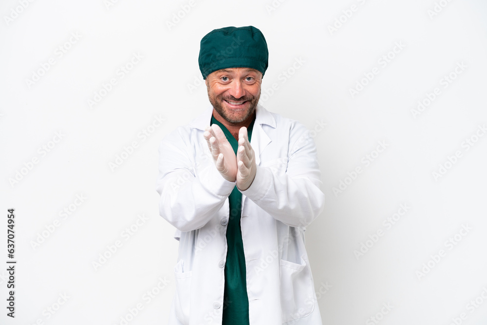 Middle age surgeon in green uniform isolated on white background applauding after presentation in a conference Middle age surgeon in green uniform isolated on white background applauding after presentation in a conference