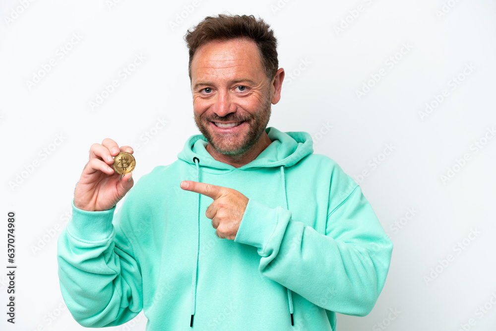 Middle age man holding a Bitcoin over isolated background pointing to the side to present a product Middle age man holding a Bitcoin over isolated background pointing to the side to present a product