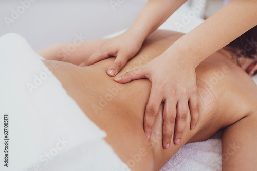 Therapist hands massaging patient at spa.