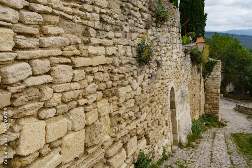 A very old wall of already destroyed stones with crumbling mortar.