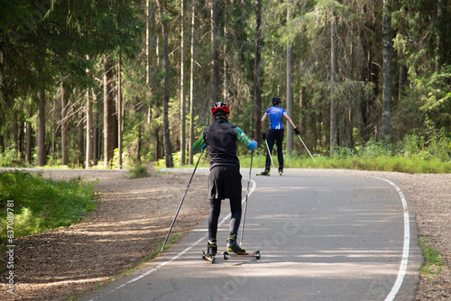 A man on a roller ski rides in the park.Cross country skilling.