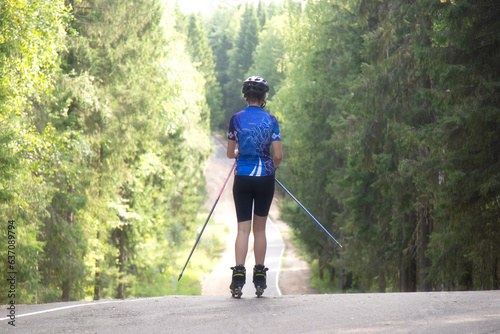 Cross country skilling.A woman on roller skis rides in the autumn park. photo