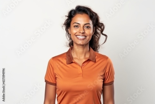 Medium shot portrait of an Indian woman in her 30s wearing a sporty polo shirt against a white background