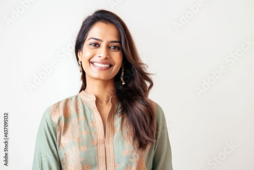 Lifestyle portrait of an Indian woman in her 30s wearing kurta pajama against a white background © Eber Braun