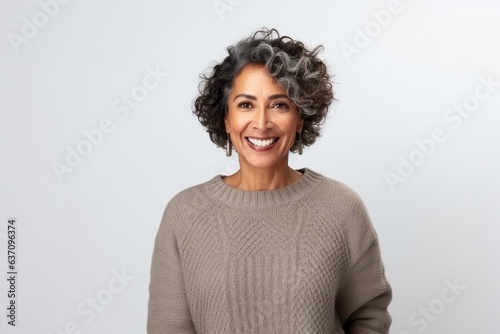 Medium shot portrait of an Indian woman in her 50s against a white background