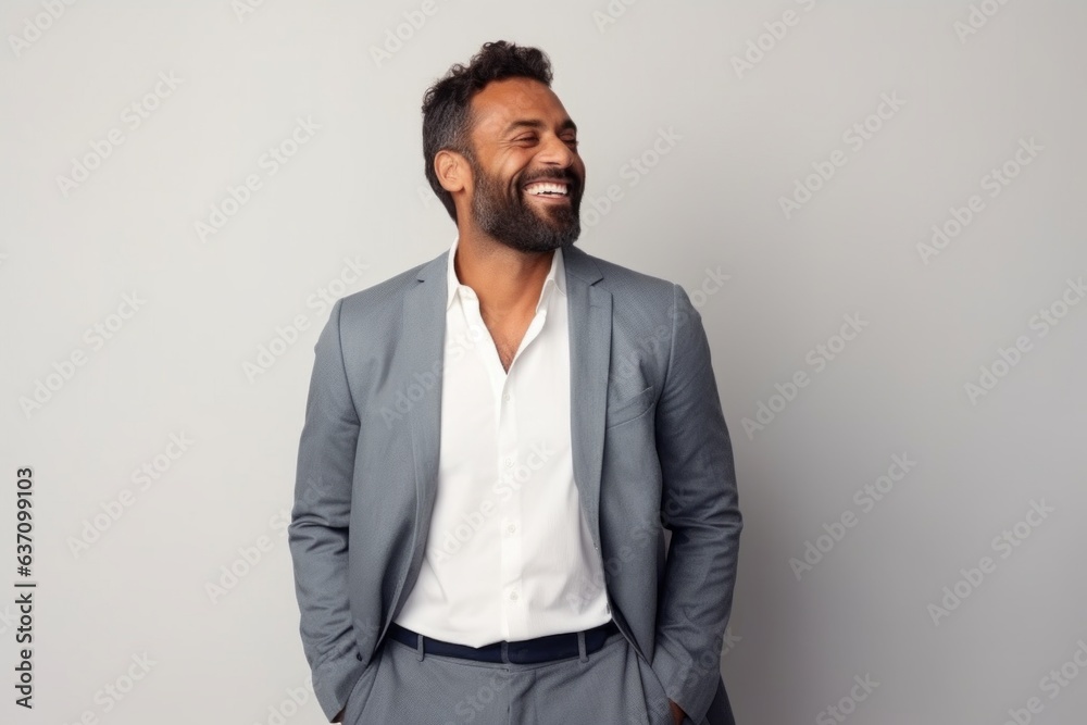 Medium shot portrait of an Indian man in his 30s in a minimalist background Medium shot portrait of an Indian man in his 30s in a minimalist background