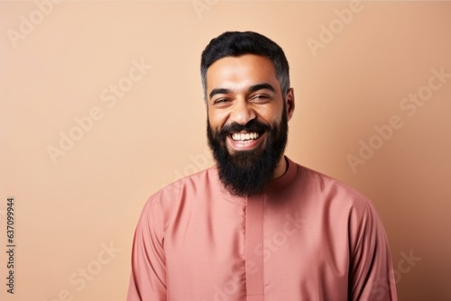 Medium shot portrait of an Indian man in his 30s wearing hijab in a minimalist background © Eber Braun