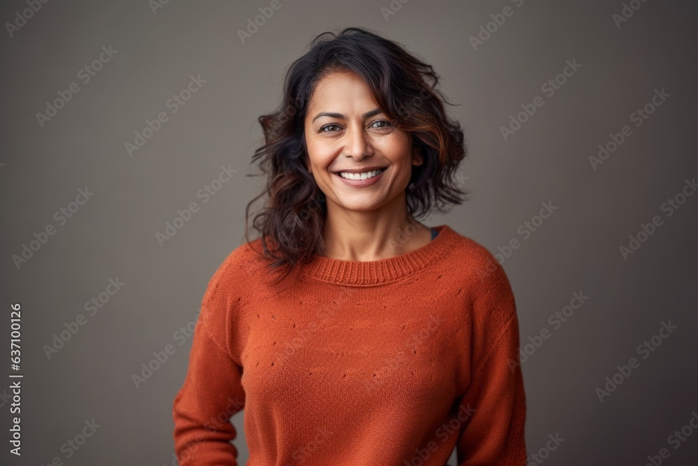 Lifestyle portrait of an Indian woman in her 40s in a minimalist background Lifestyle portrait of an Indian woman in her 40s in a minimalist background