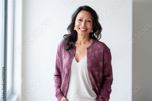 Lifestyle portrait of an Indian woman in her 40s in a minimalist background