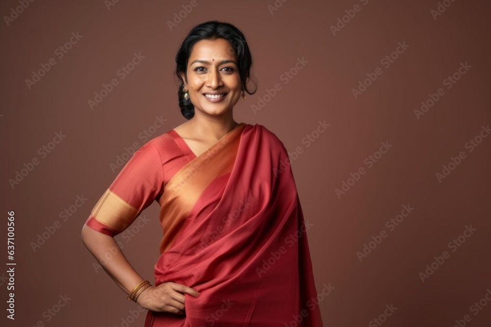 Medium shot portrait of an Indian woman in her 40s wearing traditional sari in a minimalist background Medium shot portrait of an Indian woman in her 40s wearing traditional sari in a minimalist background
