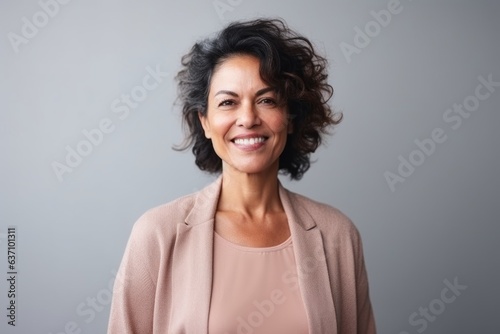Medium shot portrait of an Indian woman in her 50s in a minimalist background