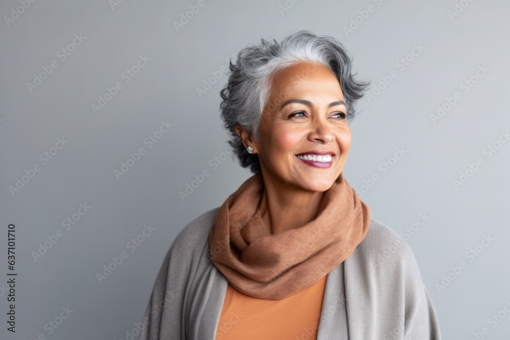 Fototapeta premium Medium shot portrait of an Indian woman in her 60s in a minimalist background
