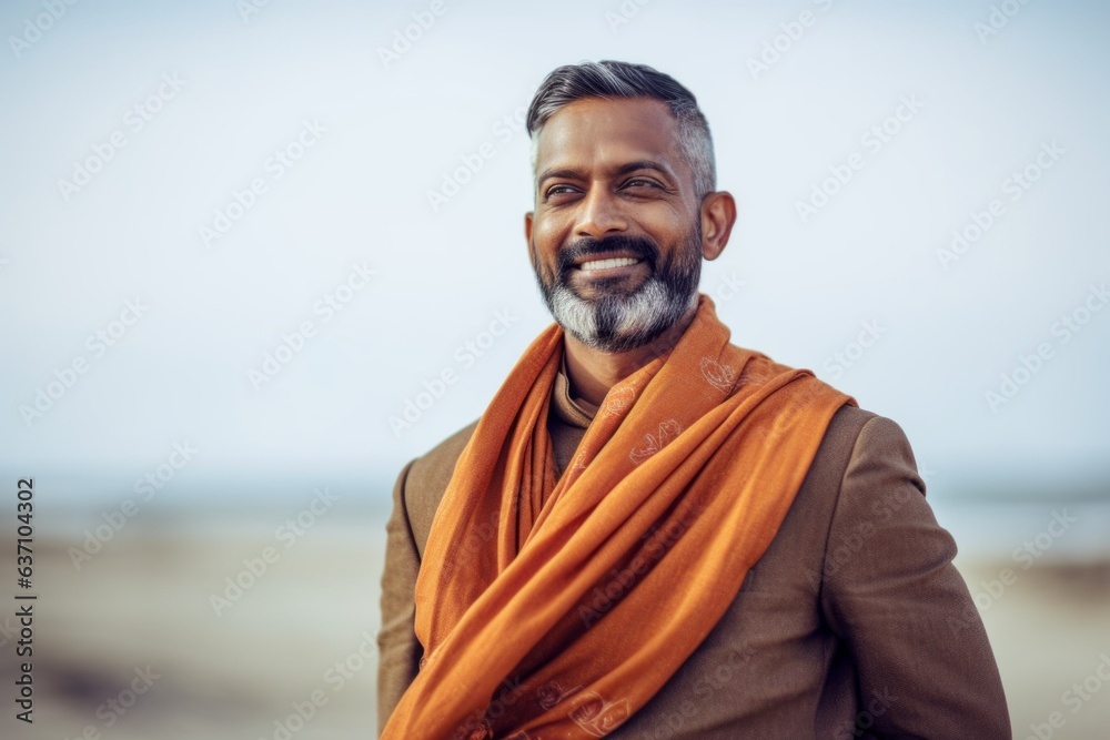Portrait of a handsome Indian man with orange scarf on the beach Portrait of a handsome Indian man with orange scarf on the beach