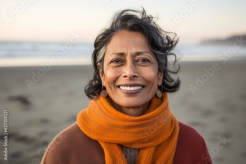 Portrait of smiling senior woman standing on the beach at autumn day © Eber Braun