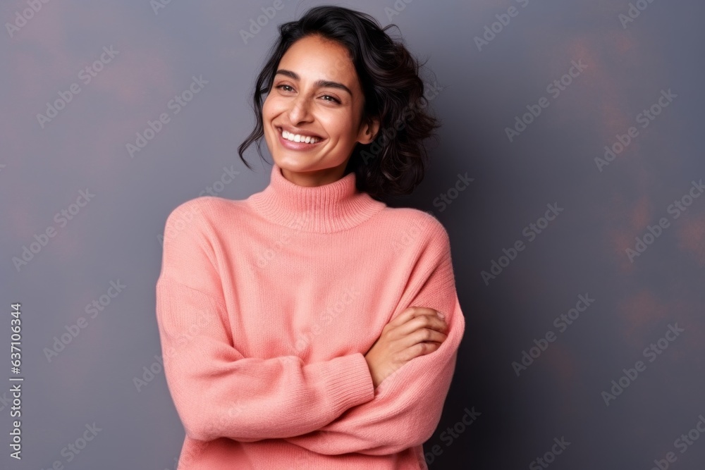 Portrait of a beautiful woman in a pink sweater on a gray background