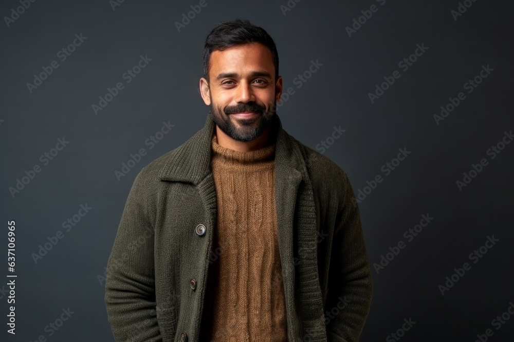 Portrait of a handsome bearded Indian man in a green sweater on a dark background Portrait of a handsome bearded Indian man in a green sweater on a dark background