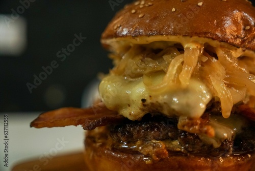 Closeup of an appetizing and tasty burger with onions, cheese and buns