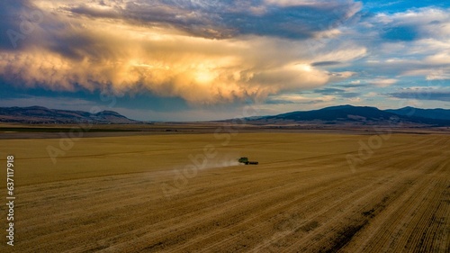Agricultural tractor in a golden field in the countryside of Montana during the Harvest Season