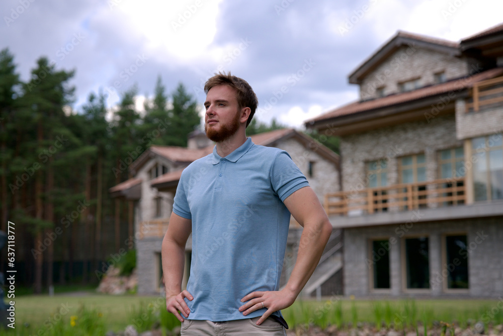 Portrait of happy young man standing in the garden outside his luxury home and smiling and relax outside 