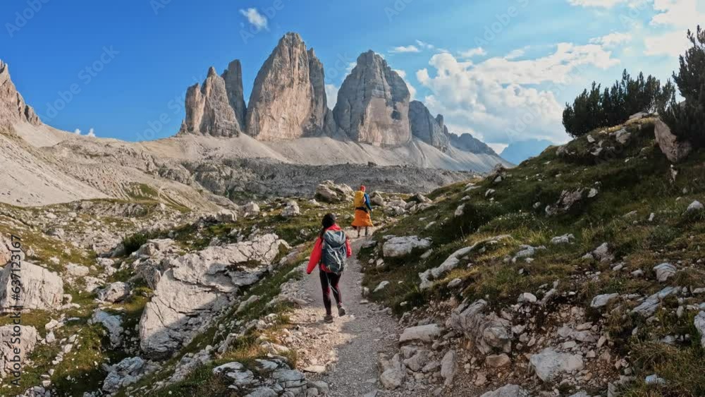 Active people with backpacks hiking trail path and climbing Tre Cime di Lavaredo Dolomites mountain. Group of friends summer adventure journey in nature. Travel exploring Alps, Dolomites, Italy Active people with backpacks hiking trail path and climbing Tre Cime di Lavaredo Dolomites mountain. Group of friends summer adventure journey in nature. Travel exploring Alps, Dolomites, Italy