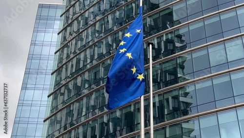 European Union flags flutter in wind against glass building facade background, Brussels, Belgium, Europe, August 5, 2023. High quality 4k footage photo