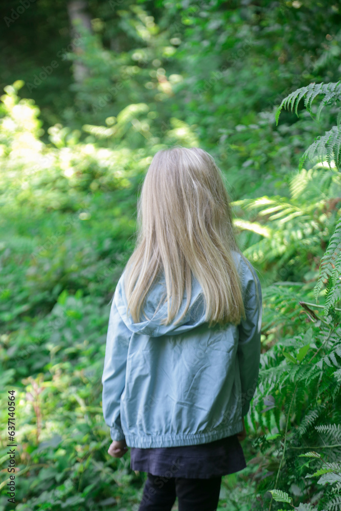 Adorable little girl hiking in the forest, spending time in the nature, outdoors experience in the countryside Adorable little girl hiking in the forest, spending time in the nature, outdoors experience in the countryside