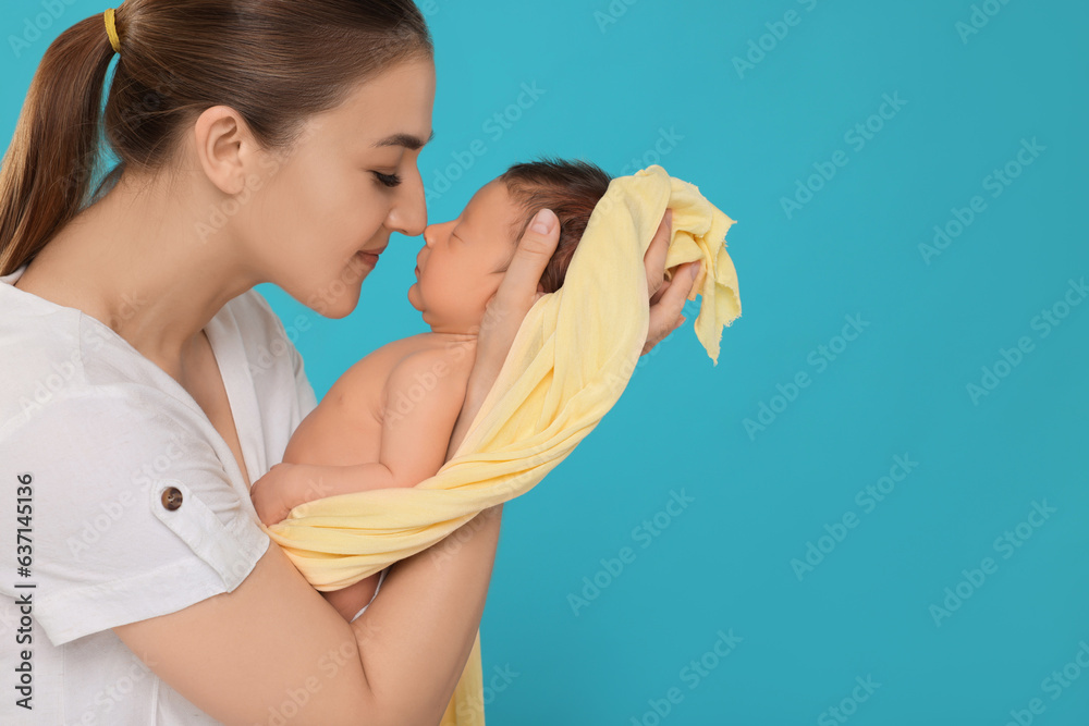 Mother with her cute newborn baby on light blue background. Space for text Mother with her cute newborn baby on light blue background. Space for text