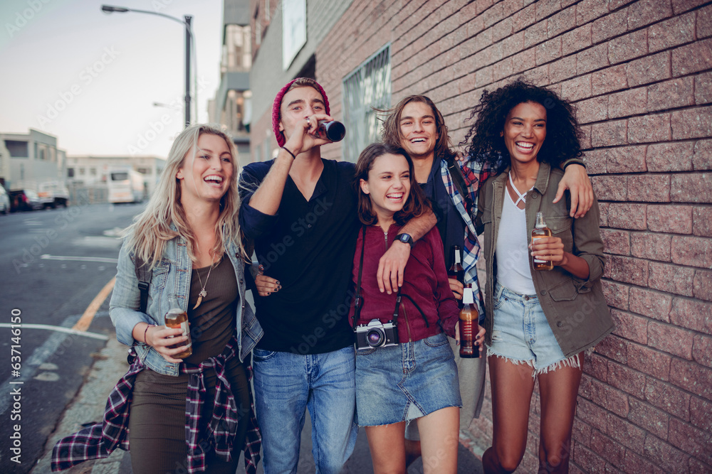 Diverse group of young people going out in the city at night and having a beer Diverse group of young people going out in the city at night and having a beer