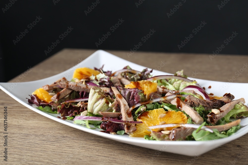 Delicious salad with beef tongue, orange and onion on wooden table, closeup Delicious salad with beef tongue, orange and onion on wooden table, closeup