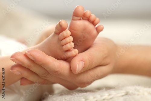 Mother holding her newborn baby, closeup view on feet. Lovely family © New Africa