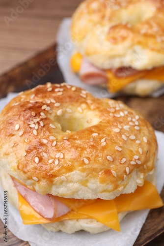 Delicious bagels with ham and cheese on table, closeup