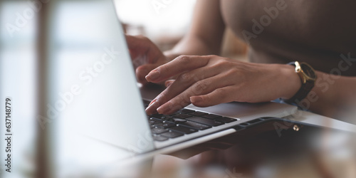Woman hands typing on laptop computer, online working at coffee shop. Woman freelancer texting on laptop keyboard, surfing the internet, seraching the information on office table, close up